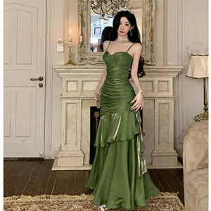 Full view of elegant mermaid green evening gown with ruffled layers and spaghetti straps