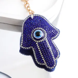 Vue détaillée d'un porte-clés main de Hamsa en strass bleus avec un œil protecteur