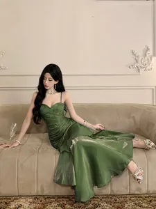 Full body view of an elegant model wearing a shimmering green mermaid evening gown
