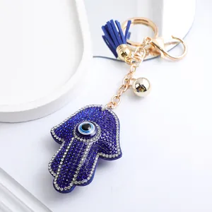 Détail du porte-clés main de Fatma avec strass bleus étincelants et pompon bleu marine