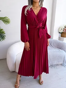 Detail of burgundy V-neck pleated maxi dress featuring a waist tie and long sleeves