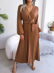 Detail view of a brown V-neck pleated maxi dress with long sleeves and belted waist
