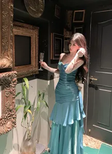 Elegant mermaid-style ruffled evening dress in shimmering teal finish, formal banquet wear.
