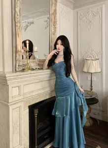 Elegant shimmering blue mermaid evening dress with ruffle details for banquet events