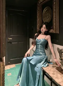 Elegant teal mermaid evening gown with ruffled hem and spaghetti straps worn by model