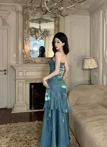 Elegant mermaid shimmer camisole gown with layered ruffles in a luxurious setting