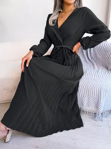 Detailed shot of the elegant black V-neck pleated maxi dress showing fine fabric texture