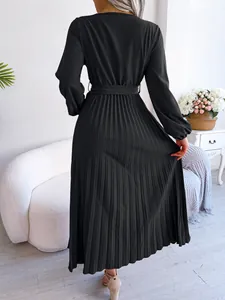 Detailed back view of an elegant black pleated maxi dress featuring long sleeves and a belt