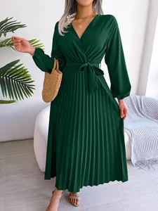 Elegant dark green pleated maxi dress with a cross V-neck and long lantern sleeves.