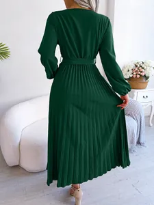Back view of dark green pleated maxi dress showing elegant flowing fabric details