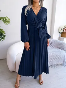 Detail showing the elegant navy blue pleated fabric and cross V-neckline design.