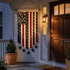 Detail view of a lighted USA flag banner hanging on a porch wall next to a wooden door