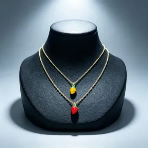 Close-up of vibrant red and yellow enamel strawberry pendants on gold necklaces for women