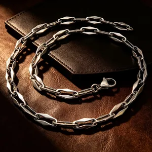 Detailed view of a geometric diamond link stainless steel chain necklace on leather