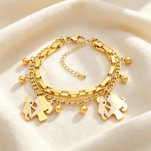 Detail view of double-layered gold bracelet with mother-child charms and pink enamel