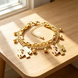 Detail view of gold double-layer stainless steel bracelet with mother child charms