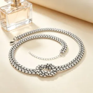 Detailed view of a chunky stainless steel double-layer necklace with central knot.