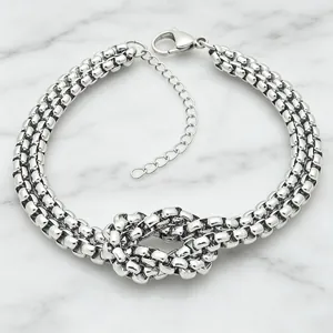 Close-up detail of double-layered stainless steel box chain bracelet with center knot design