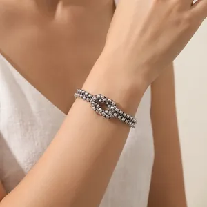 Macro view showing detail of silver stainless steel double-layered knot chain bracelet on wrist