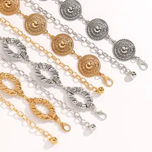 Close-up of decorative ethnic style metal waist chains in gold and silver finishes.