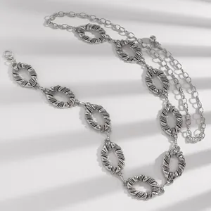 Detailed view of silver textured oval link waist chain with lobster clasp for women