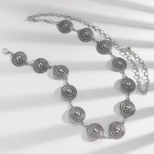 Detail view of ethnic silver metal chain belt with ornate circular medallion patterns