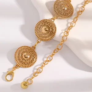 Macro detail of ornate gold-tone metal waist chain with vintage sunburst motifs