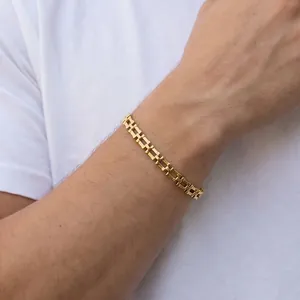 Gros plan d'un élégant bracelet à maillons en acier inoxydable doré au poignet.