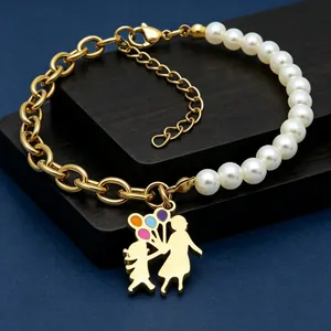 Detail view of a gold titanium steel bracelet with pearls and a mother-child pendant
