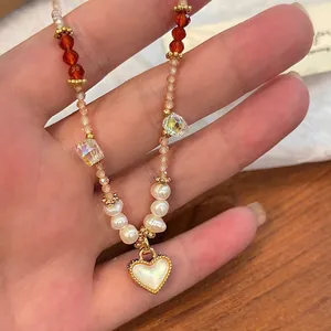 Detailed view of elegant beaded necklace with a heart pendant and natural pearls