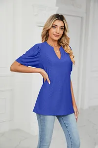Close-up of women's blue V-neck top featuring eyelet embroidery and puff sleeves.