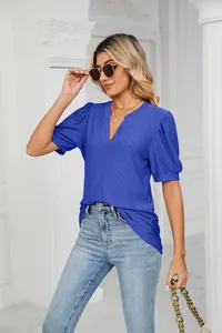 Close-up of blue V-neck puff sleeve T-shirt with intricate eyelet pattern detailing.