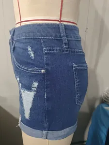 Vue détaillée d'un short en jean bleu taille haute avec déchirure sur mannequin de couture.