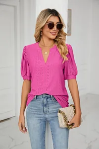 Detail shot of a pink eyelet V-neck summer top featuring puff sleeves and lace embroidery