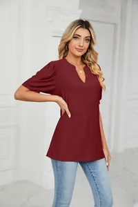 Detailed view of women's burgundy V-neck blouse featuring eyelet patterns and puff sleeves