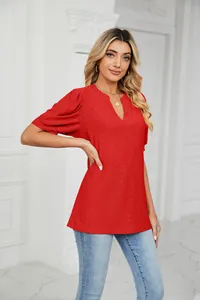 Detail view of a red V-neck eyelet puff sleeve blouse on a female model in a bright room.