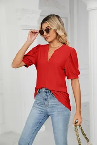 Detailed view of red V-neck top with elegant eyelet embroidery and puff sleeves