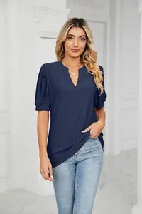 Detailed view of women's navy blue V-neck top with textured eyelet fabric and puff sleeves