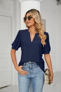 Elegant woman wearing navy blue casual V-neck eyelet puff sleeve shirt with jeans
