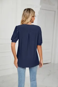 Detailed back view of a navy blue puff sleeve blouse with eyelet embroidery motifs