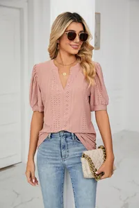 Fashion detail of women's pink eyelet puff sleeve top with casual V-neckline design