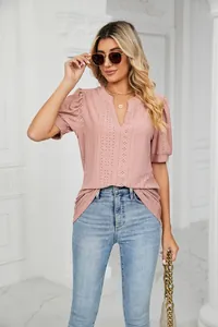 Detail view of pink V-neck eyelet T-shirt with puff sleeves and intricate embroidery