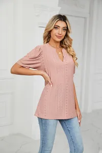 Detail view of a pink V-neck puff sleeve blouse with intricate eyelet embroidery