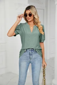 Detail view of a women's sage green V-neck puff sleeve t-shirt with intricate eyelet pattern