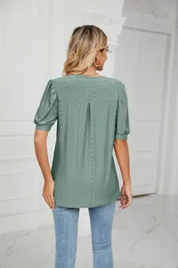 Detailed back view of a sage green eyelet hollow-out blouse with elegant puff sleeves