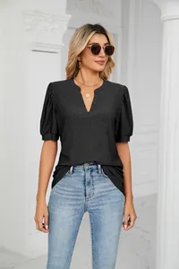Detailed view of elegant black V-neck summer blouse with eyelet texture and puff sleeves