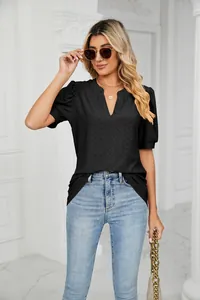 Detail shot of black V-neck top with puff sleeves and subtle eyelet perforated texture