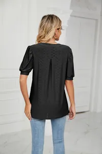 Rear view of black hollow-out puff sleeve blouse with textured eyelet fabric detail.