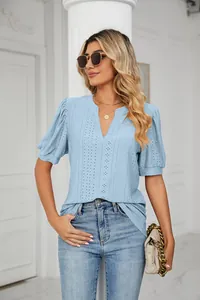 Detailed view of women's blue eyelet puff sleeve V-neck blouse