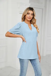 Women's light blue V-neck top featuring eyelet embroidery and stylish puff sleeves.